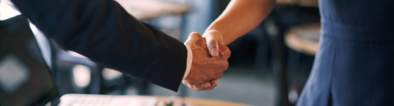 A business woman and man shaking hands